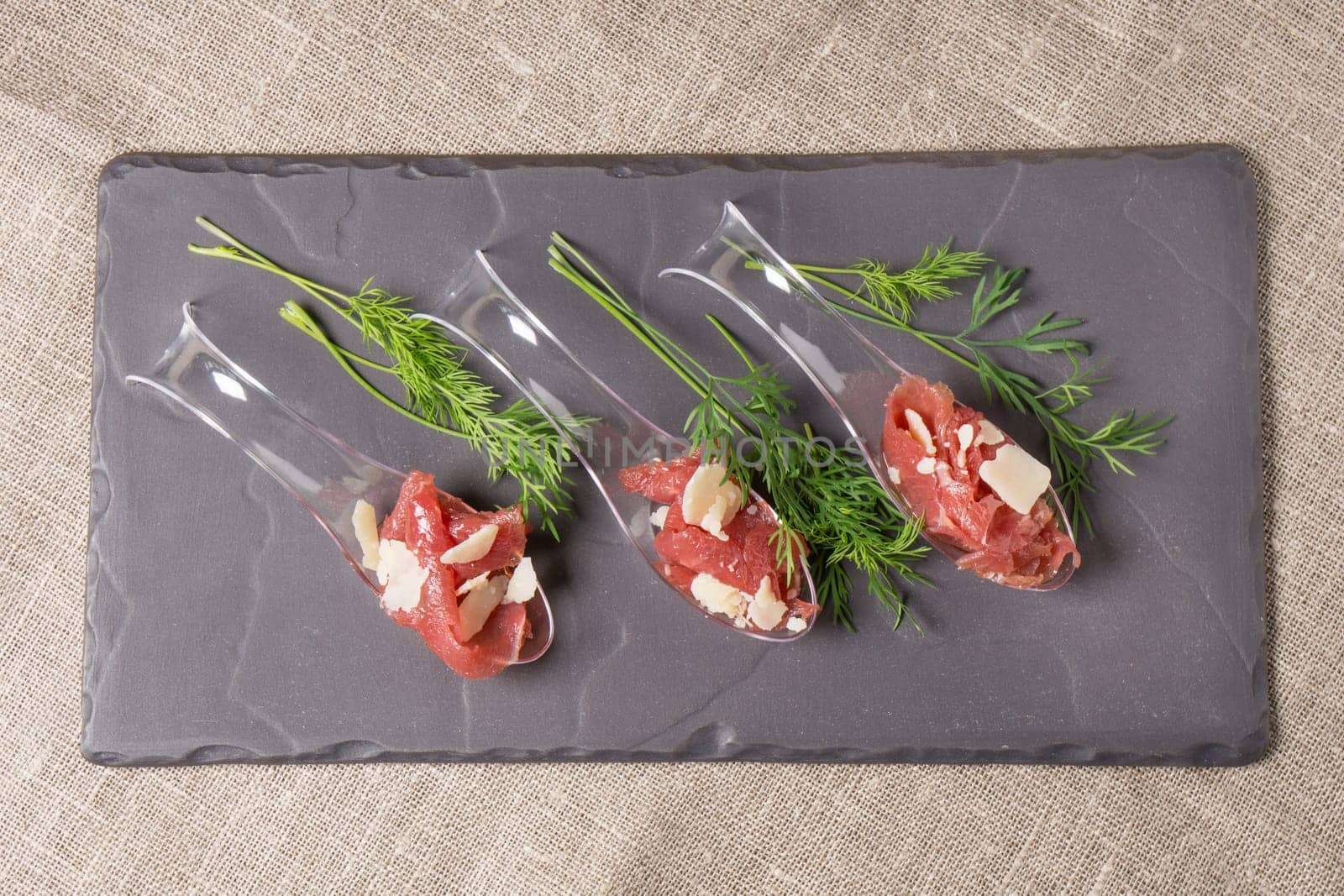 Appetizer with meat, Carpaccio and parmesan served on a Spoon