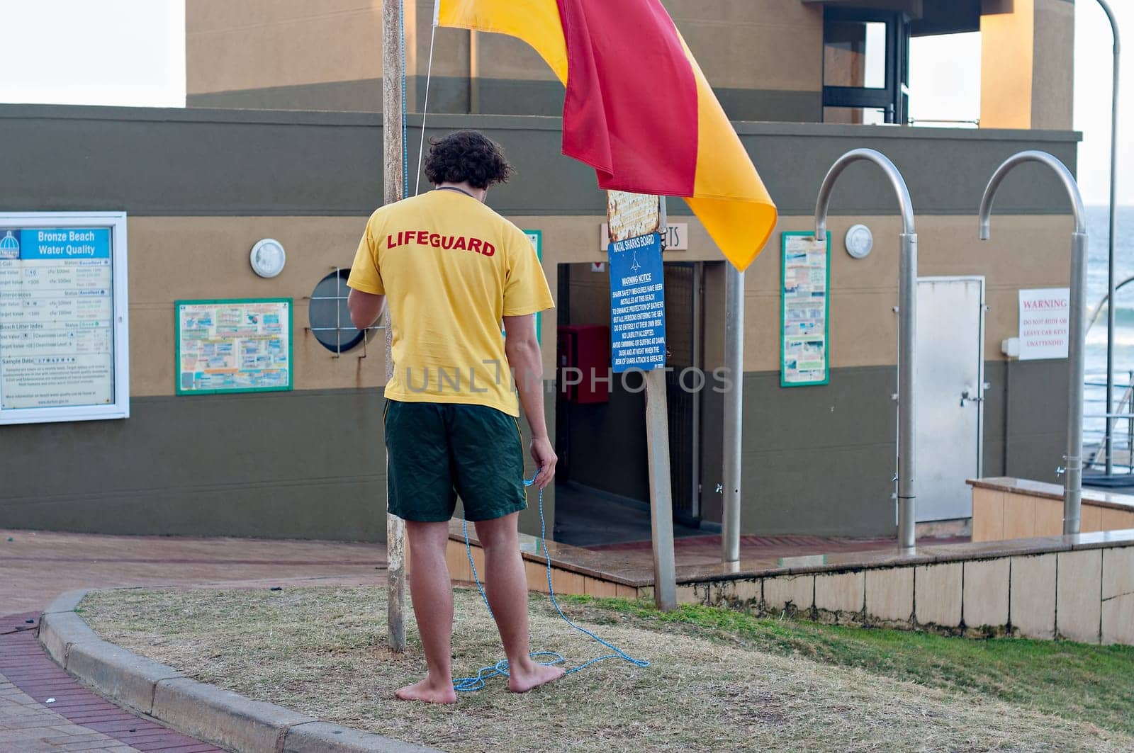 DURBAN, SOUTH AFRICA - JULY 13, 2016: Lifeguard raising the flag at the Bronze Beach surf rescue station in Umhlanga Rocks