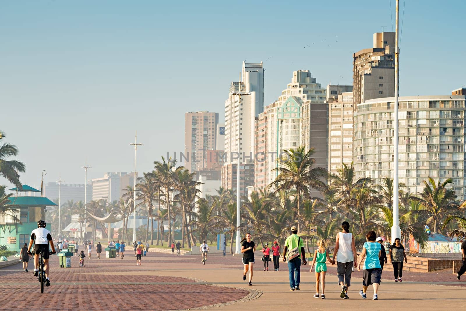 DURBAN, SOUTH AFRICA - APRIL 16, 2016: Locals and Tourists enjoying the Golden Mile Promenade just after sunrise.