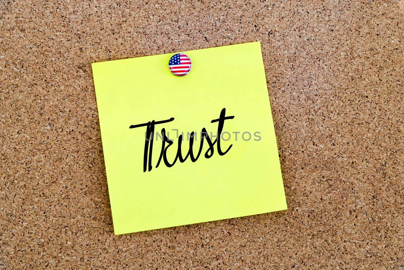 Written text Trust over yellow paper note pinned on cork board