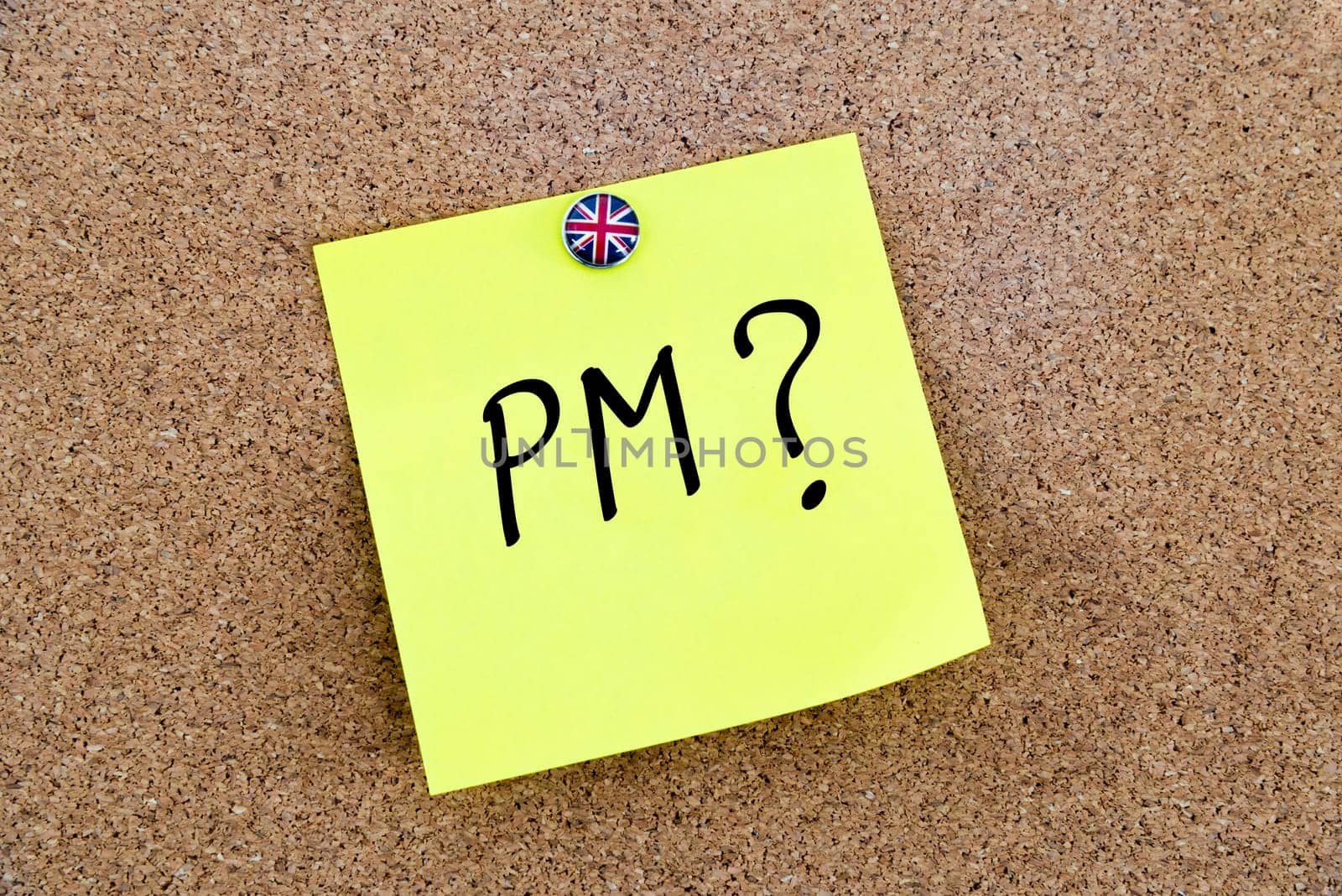 Yellow paper note pinned on cork board with Great Britain flag thumbtack, written text PM as Prime Minister, British Business concept