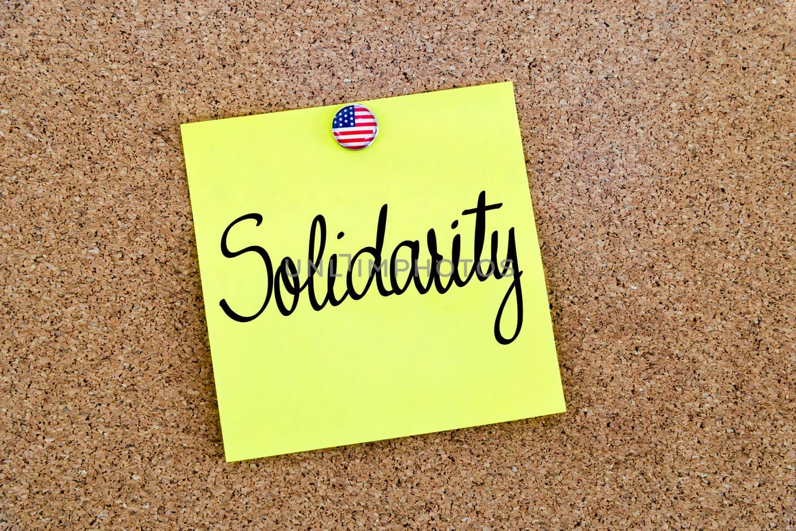Written text Solidarity over yellow paper note pinned on cork board