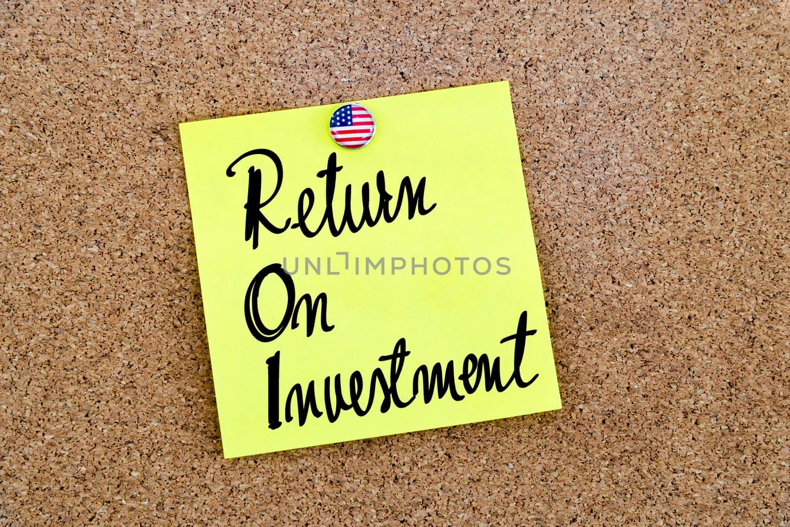 Written text ROI Return On Investment over yellow paper note pinned on cork board