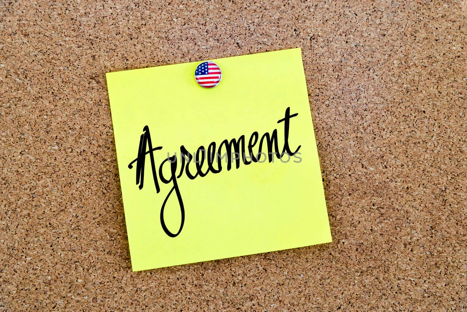Written text Agreement over yellow paper note pinned on cork board