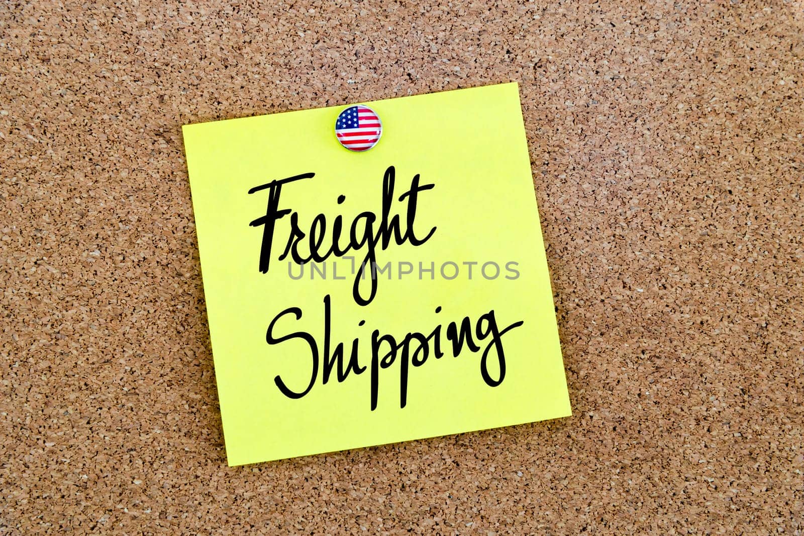 Written text Freight Shipping over yellow paper note pinned on cork board