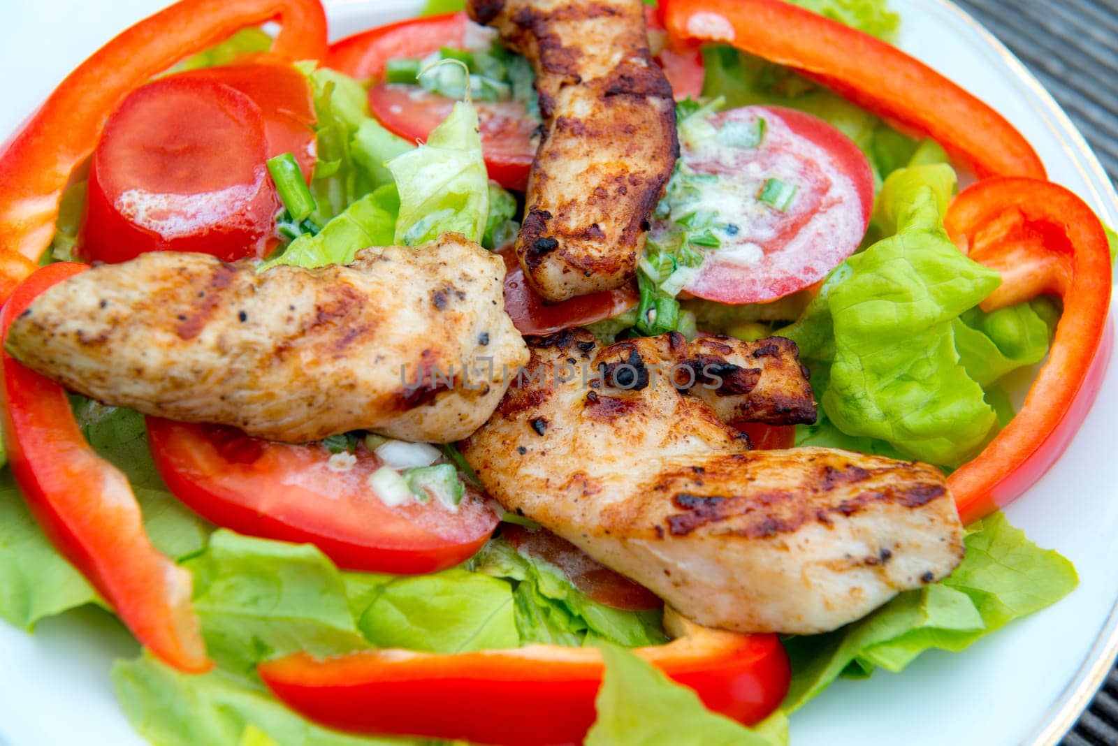 fresh salad with chicken filet and white dressing