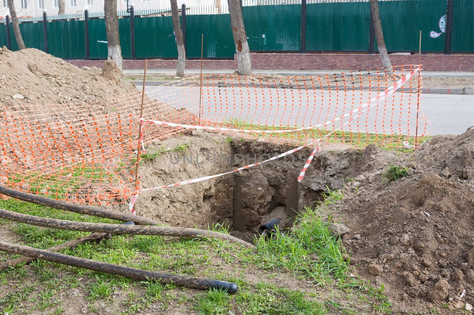 Dug pit fenced for replacing electric cables underground