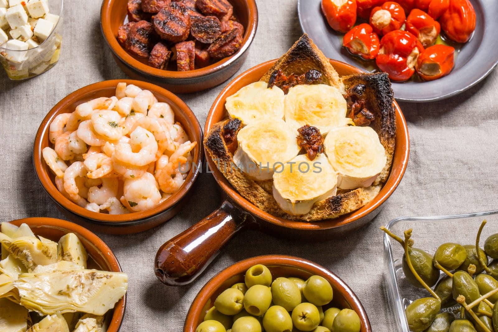 Tapas food, served in small bowls cold meat, goat cheese. A meal for sharing