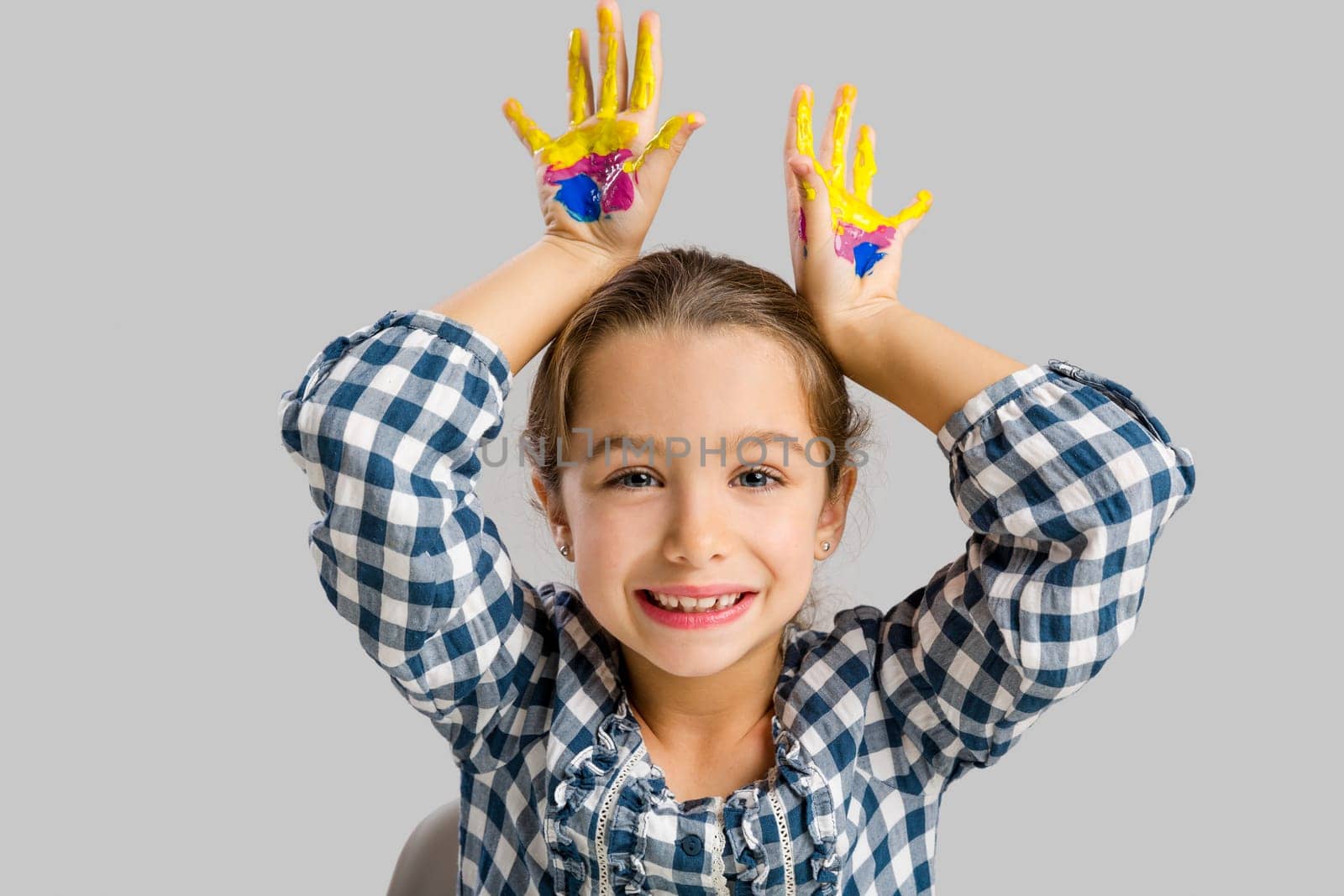 Cute smiling little girl with hands in paint