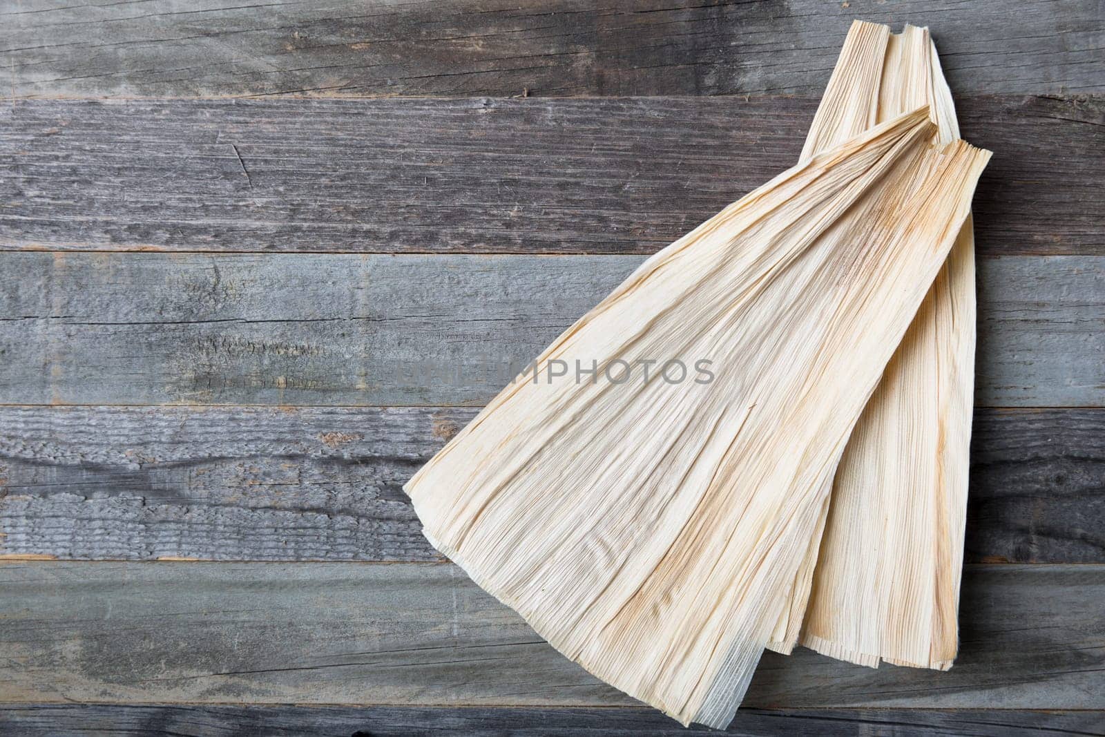 Corn  husks on weathered wooden surface with copy space.