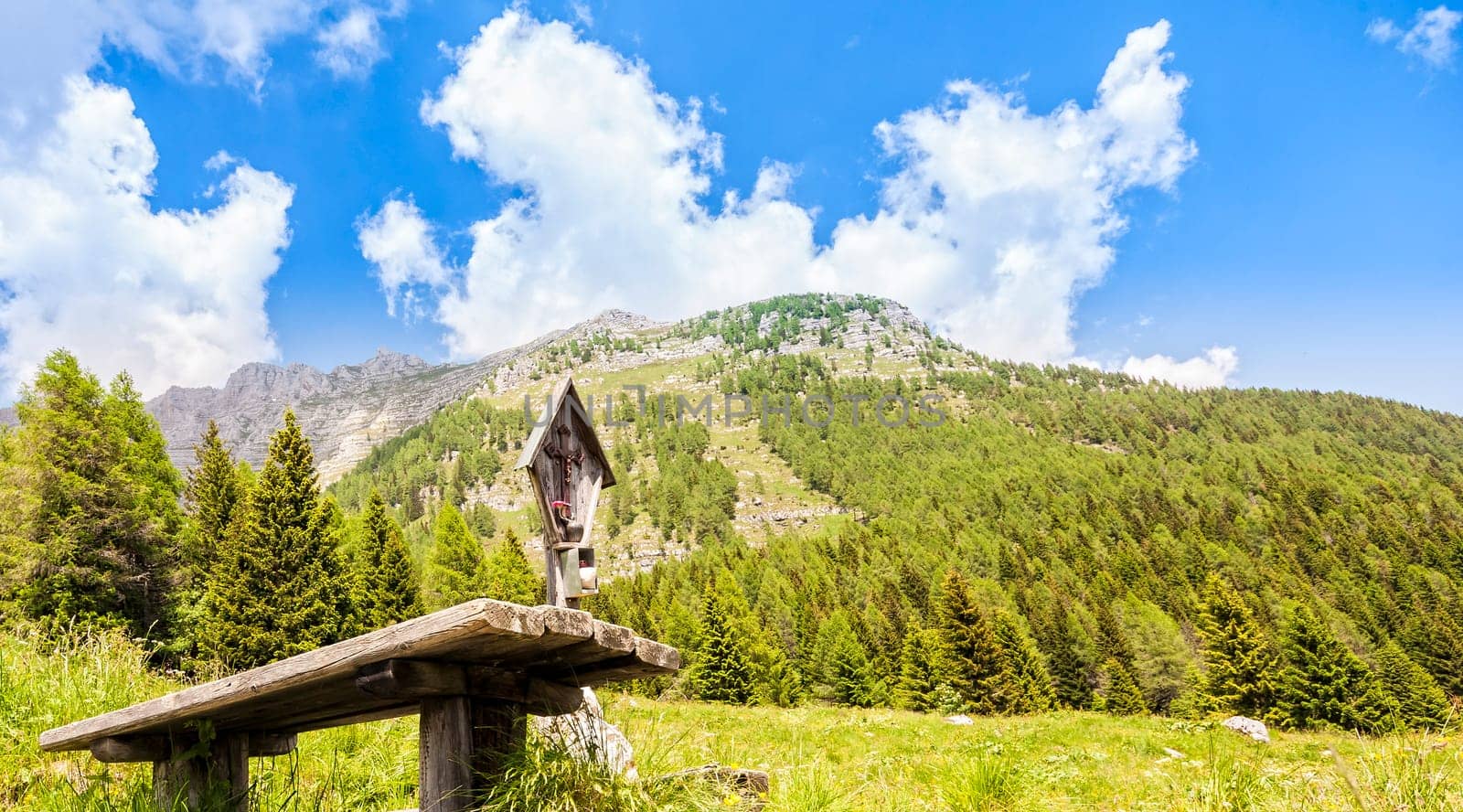 Mountain panorama with table and benches for resting and crucified. Julian Alps Friuli, Italy