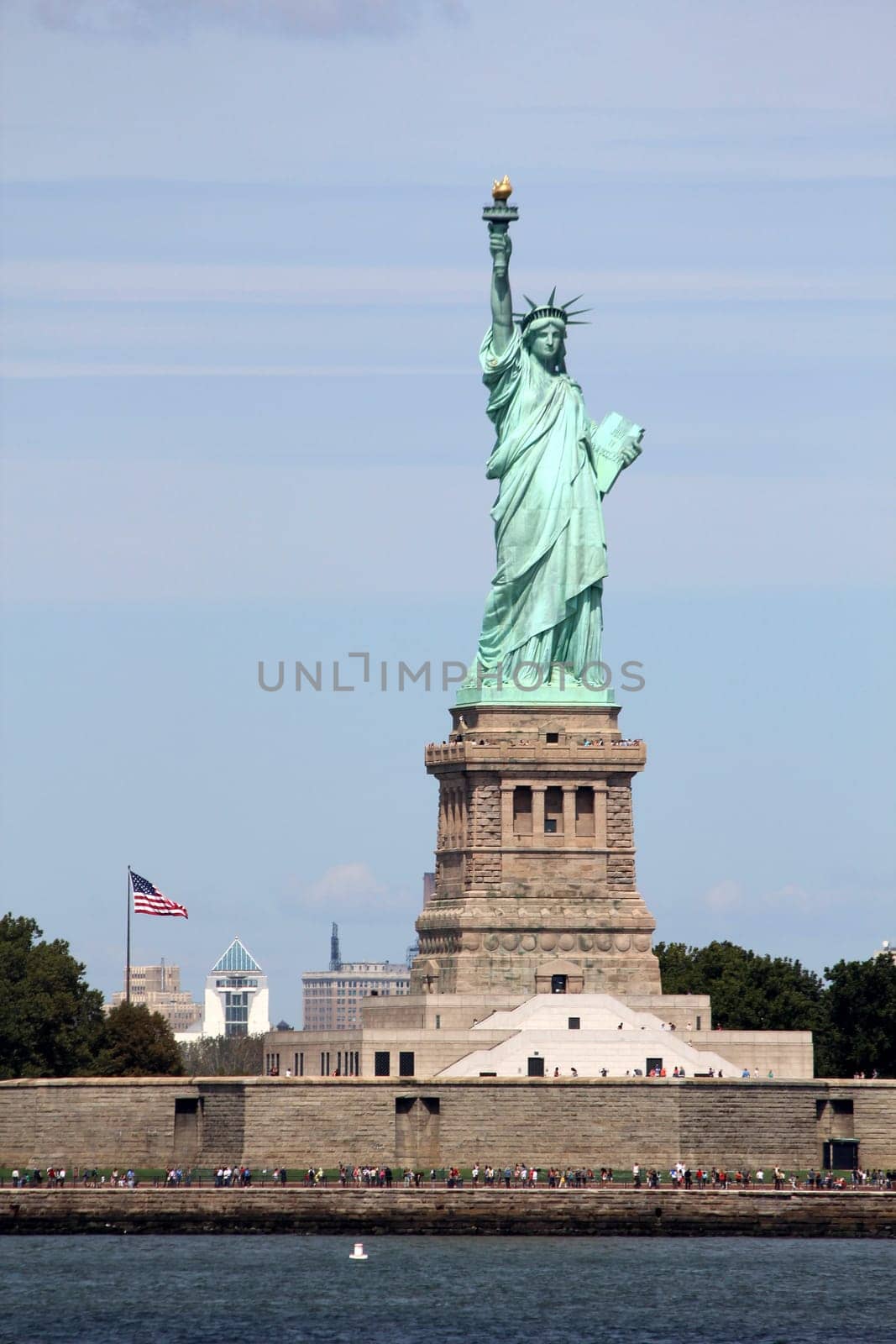 The Statue of Liberty (Liberty Enlightening the World), a colossal neoclassical sculpture on Liberty Island in the middle of New York Harbor, Manhattan. The statue is of a robed female figure representing Libertas, the Roman goddess of freedom, who bears a torch and a tabula ansata