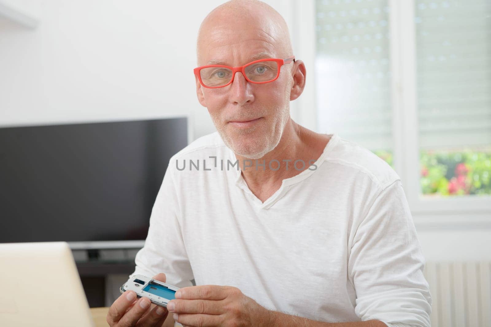 man with glasses repaired a smartphone