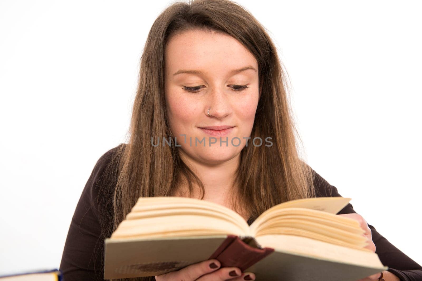 young woman in front of white background is reading