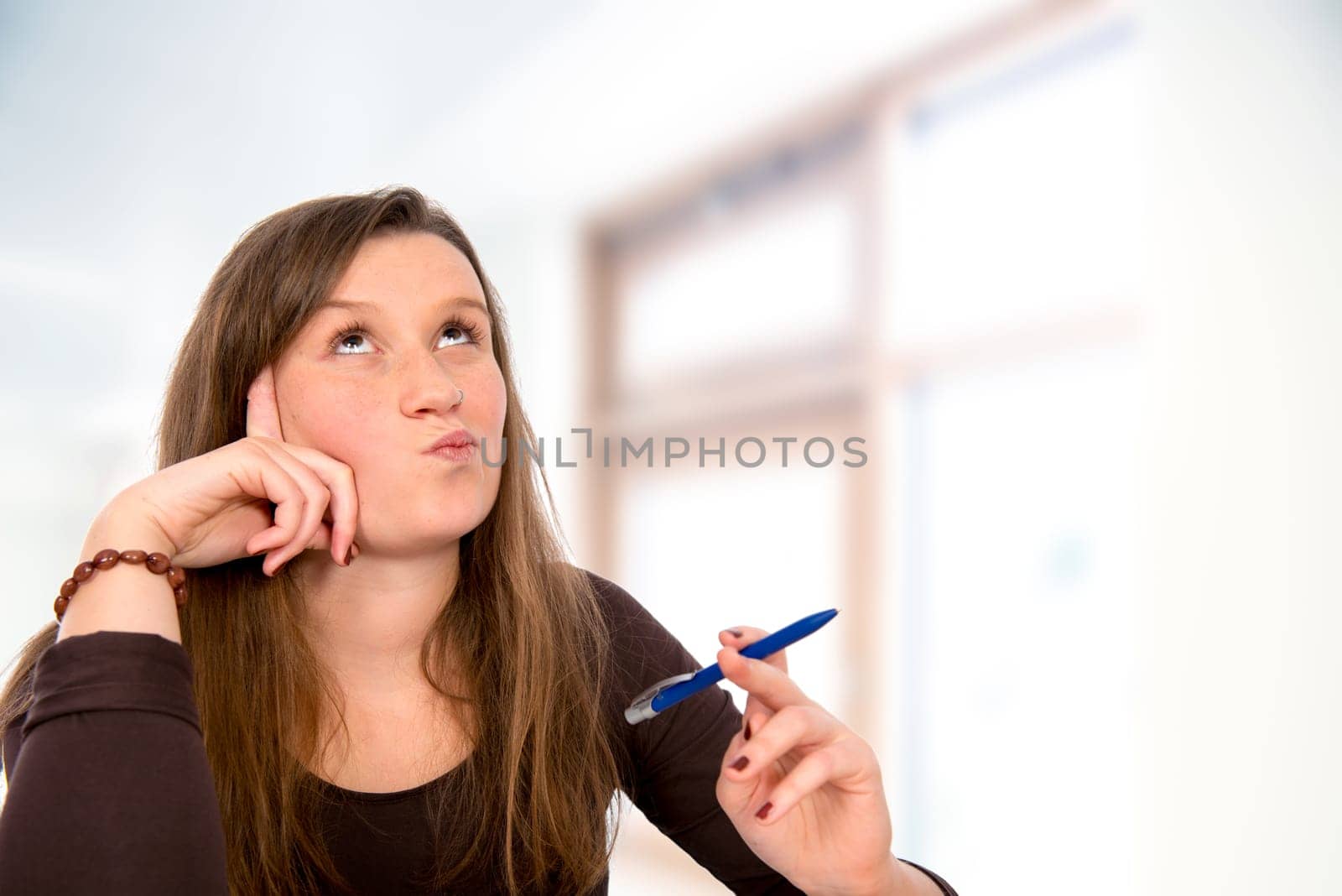 young woman with pen is reflecting