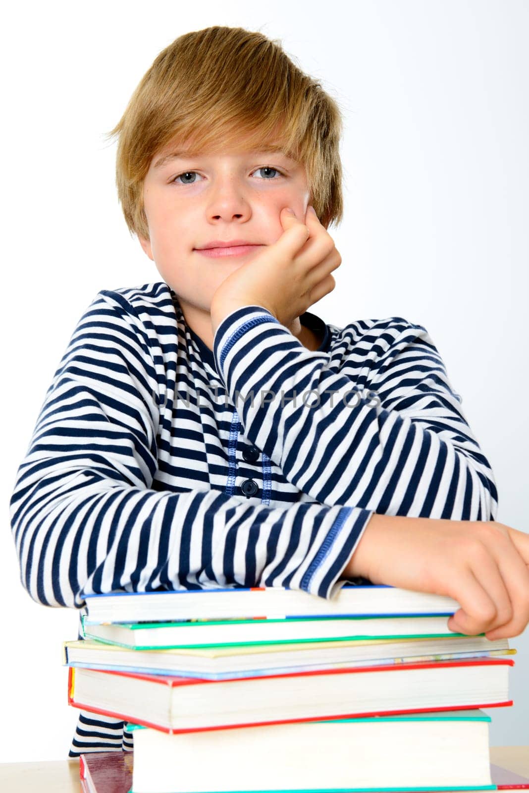 blond boy on a pile of books