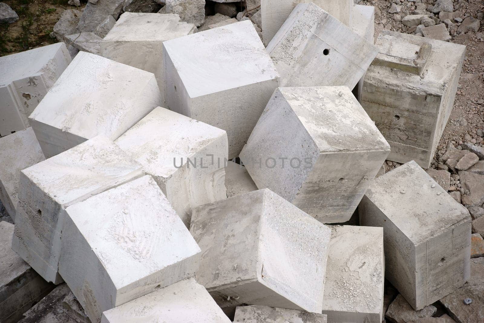 A pile of piled up and milled out cube-shaped concrete blocks.