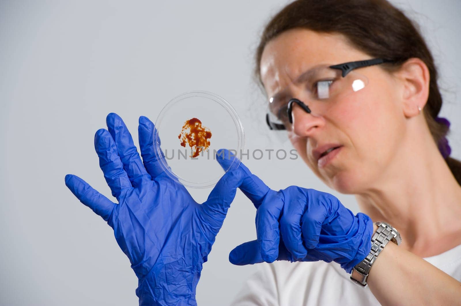 dark haired female lab assistand with Petri dish