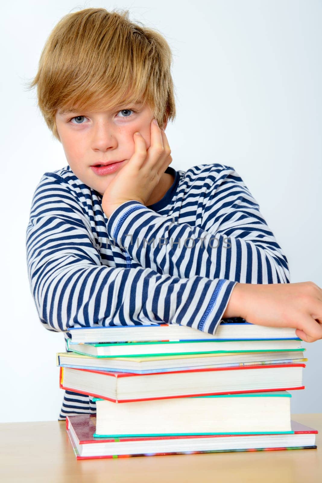 blond boy on a pile of books