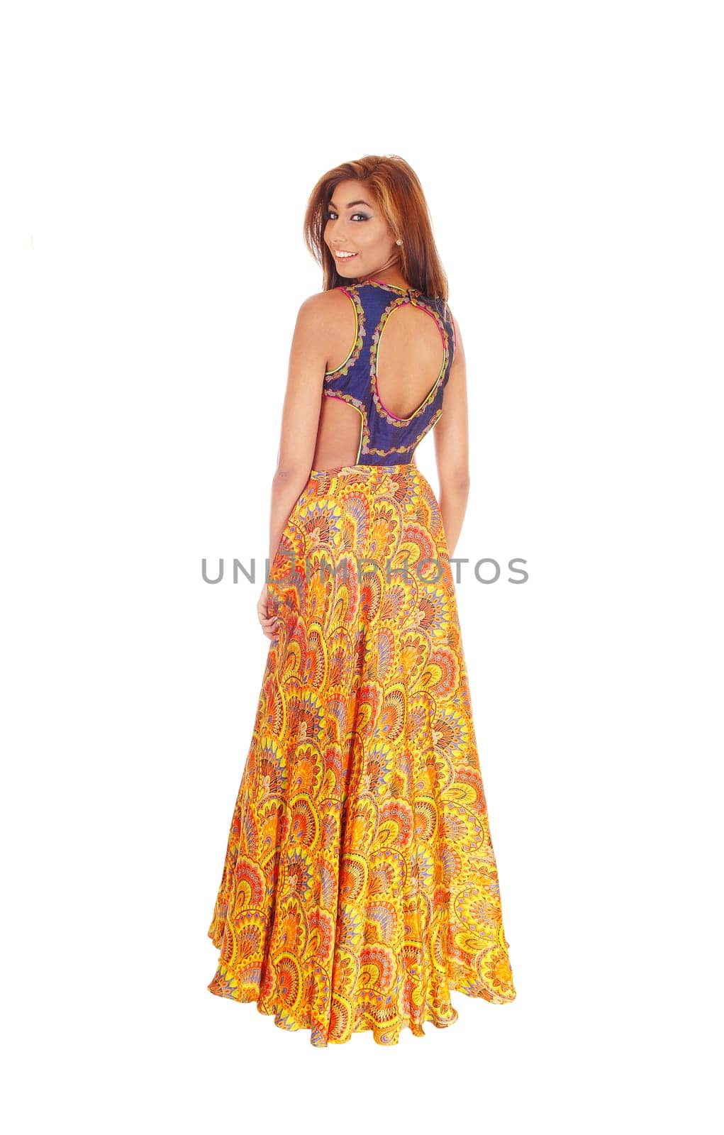 A beautiful young slim woman in a long yellow skirt standing in full length.isolated for white background, looking over her shoulder..