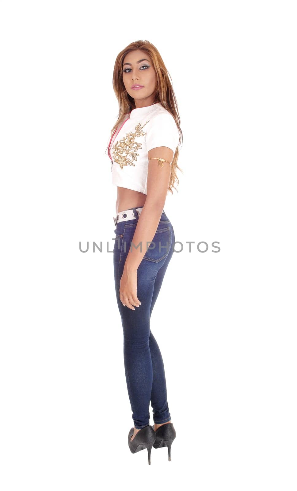 A tall beautiful young woman standing in jeans and a white blouse with.gold embroidery, isolated for white background..
