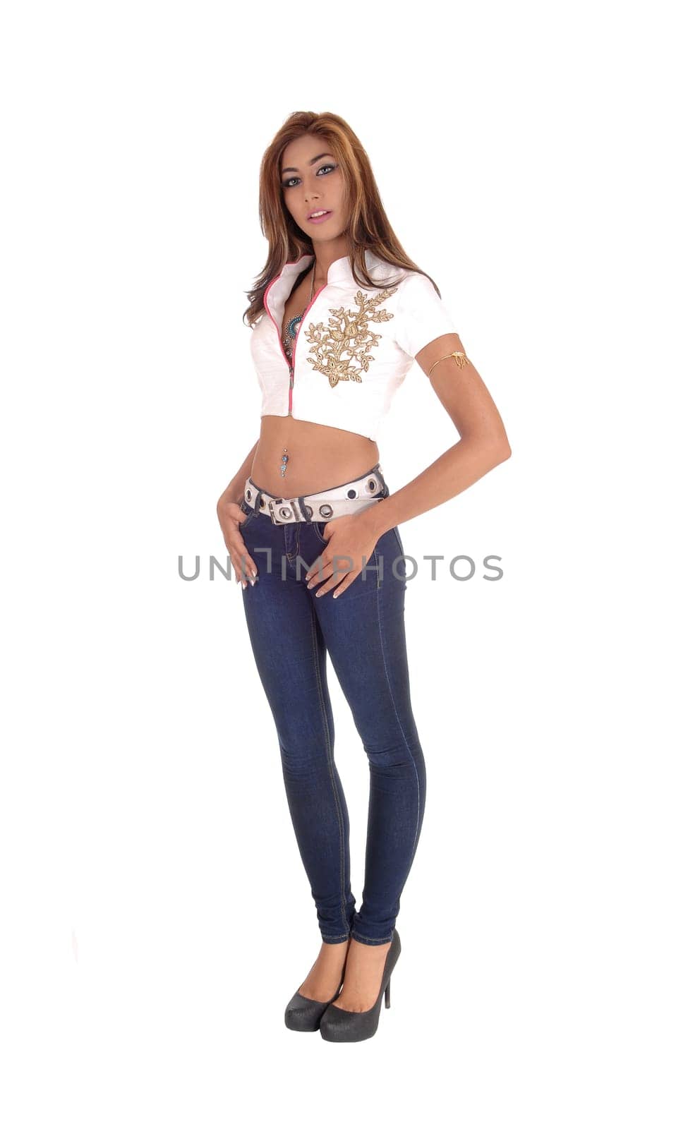 A beautiful young tall woman standing in jeans, high heels and white .blouse isolated for white background with her hands in pocket..