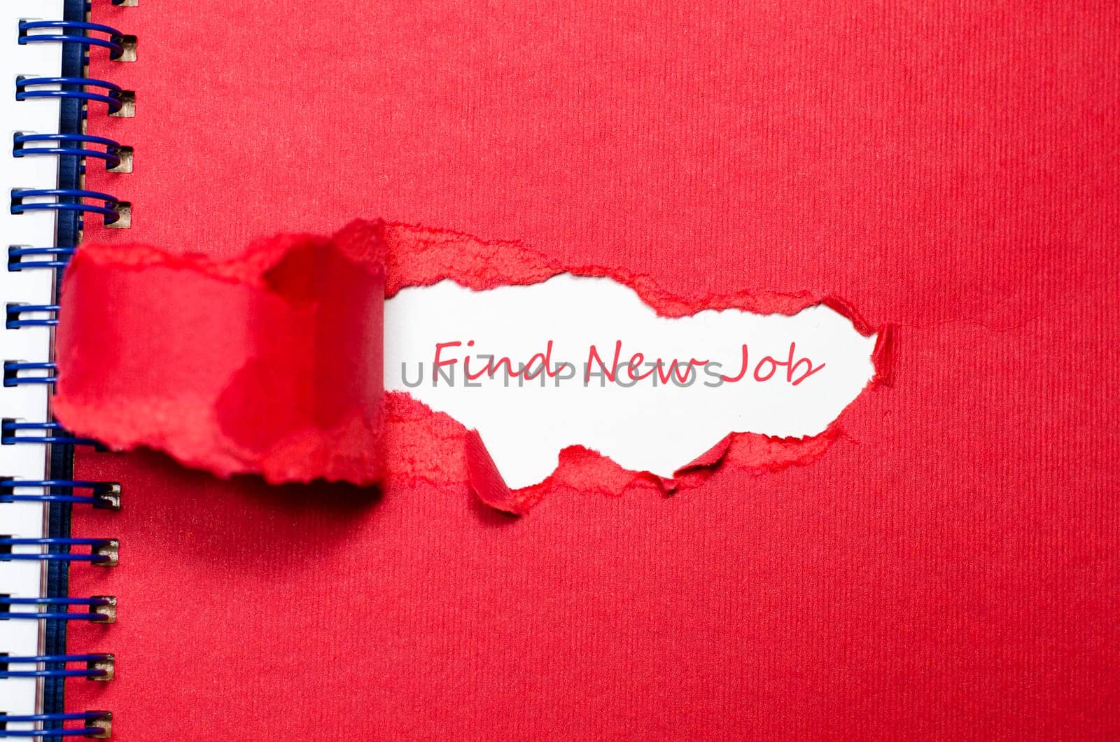 The word find new job appearing behind torn paper