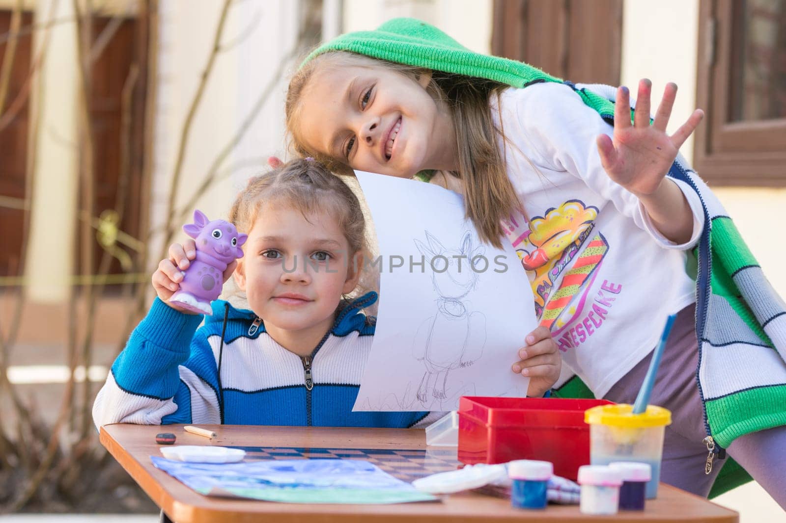 Vityazevo, Russia - April 24, 2016: Two girls painted Luntik at a table in the garden