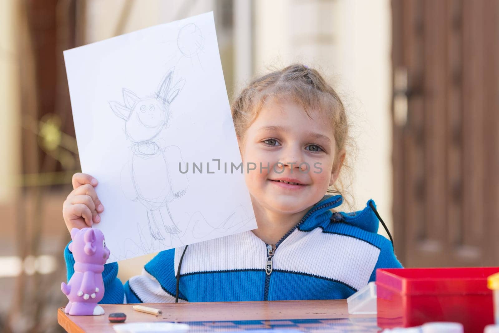 Vityazevo, Russia - April 24, 2016: Girl painted Luntik at a table in the garden