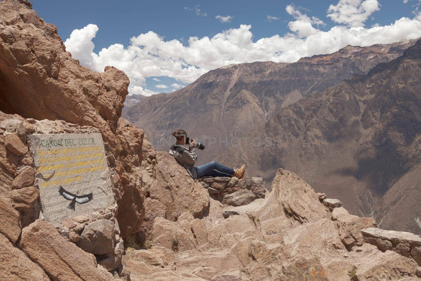 Young woman photographing condors in Colca, Arequipa, Peru.