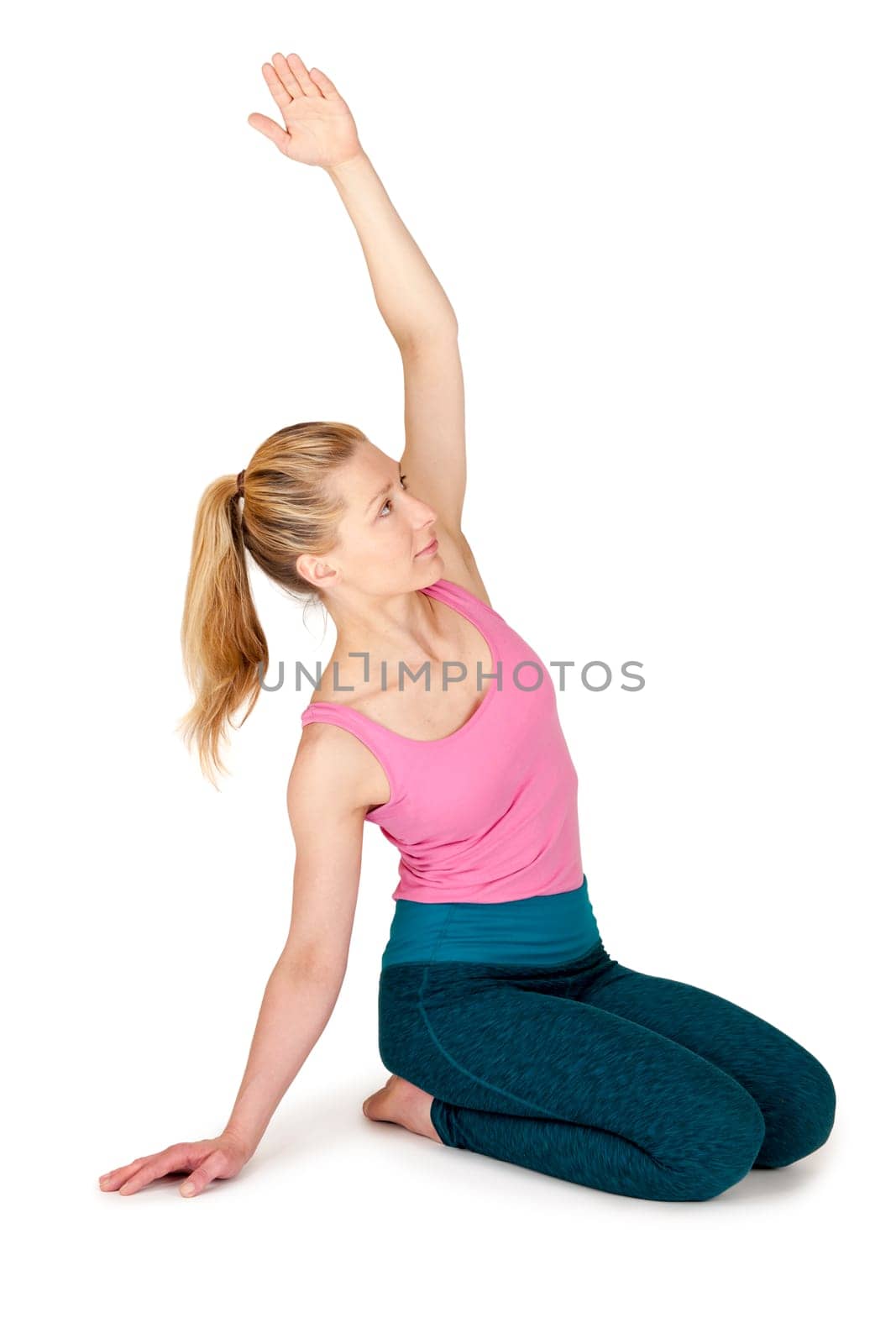 Full body view of a young blonde woman during yoga exercise "Lower leg seat with arm stretched upwards"" against a white background with a slight shadow."