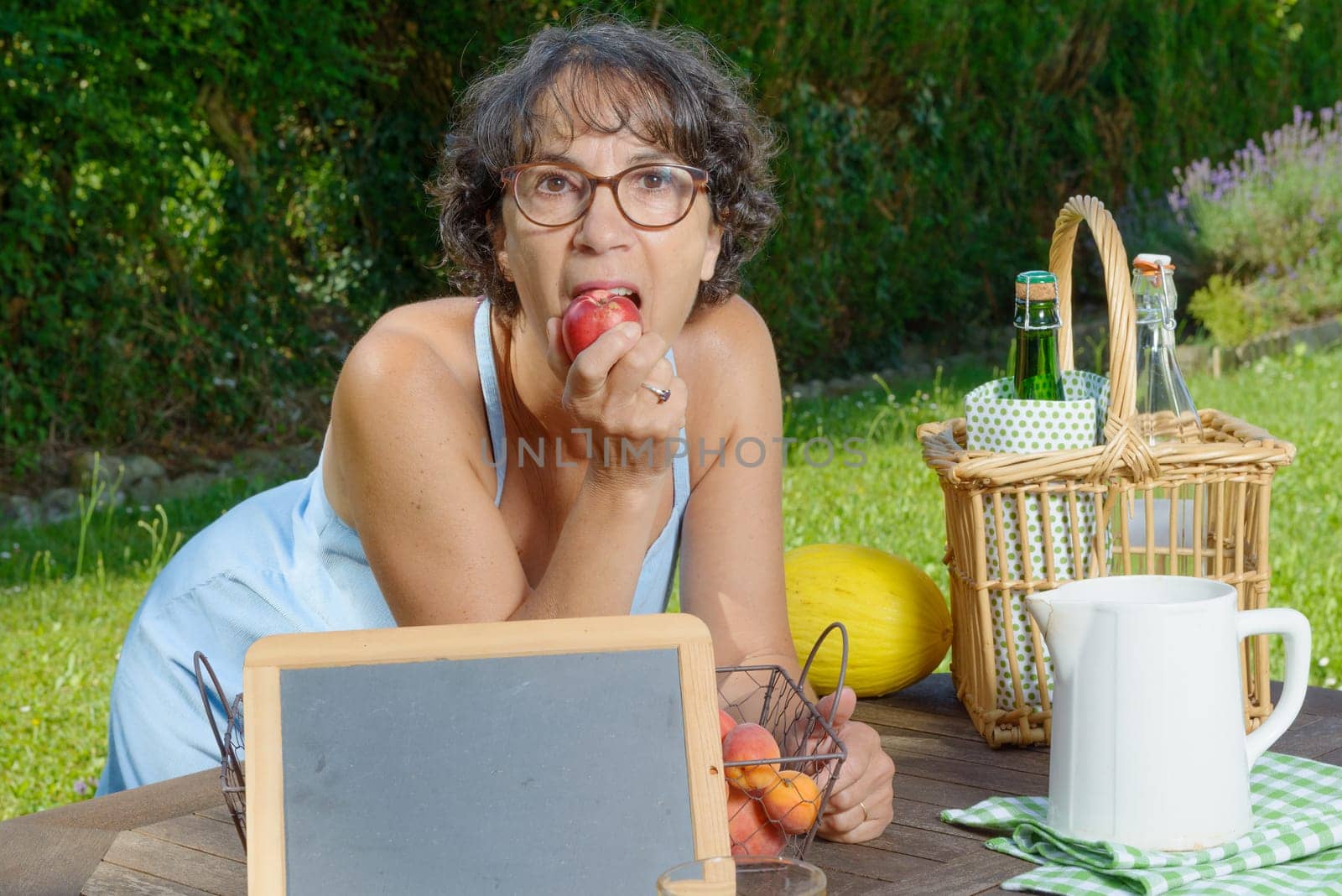 a beautiful mature woman eating a peach