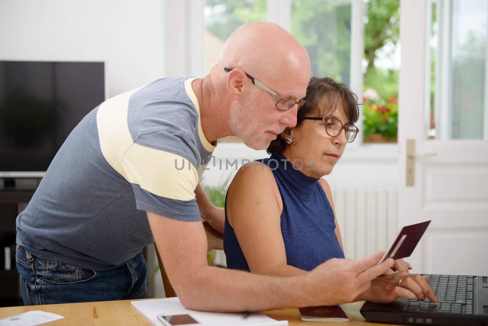 a senior couple prepare the holidays on the internet