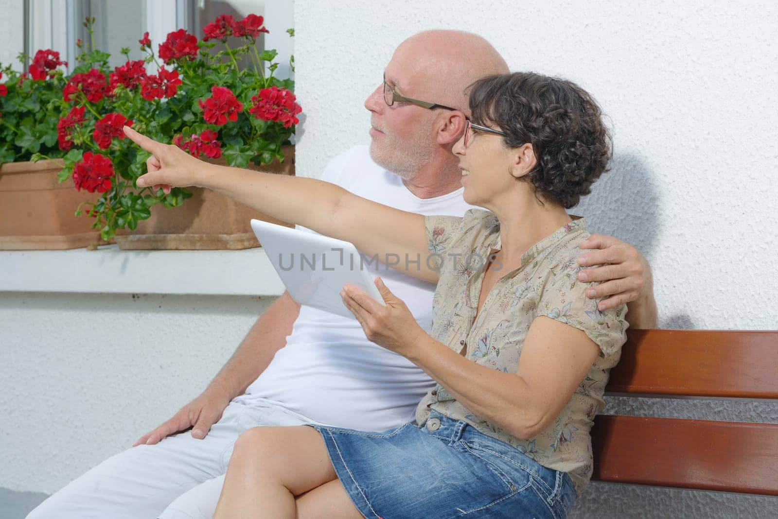 a senior couple with a tablet, outside