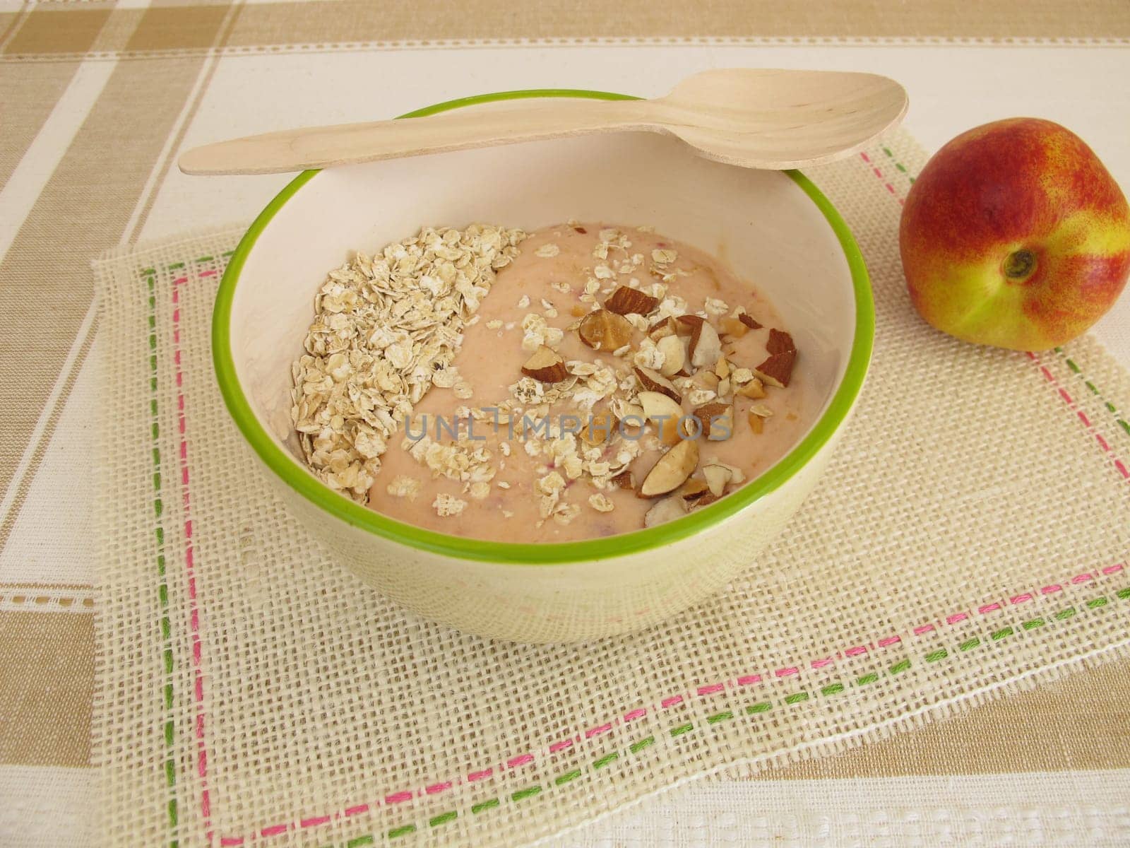 Smoothie bowl for spooning with oatmeal,nectarines and hazelnuts