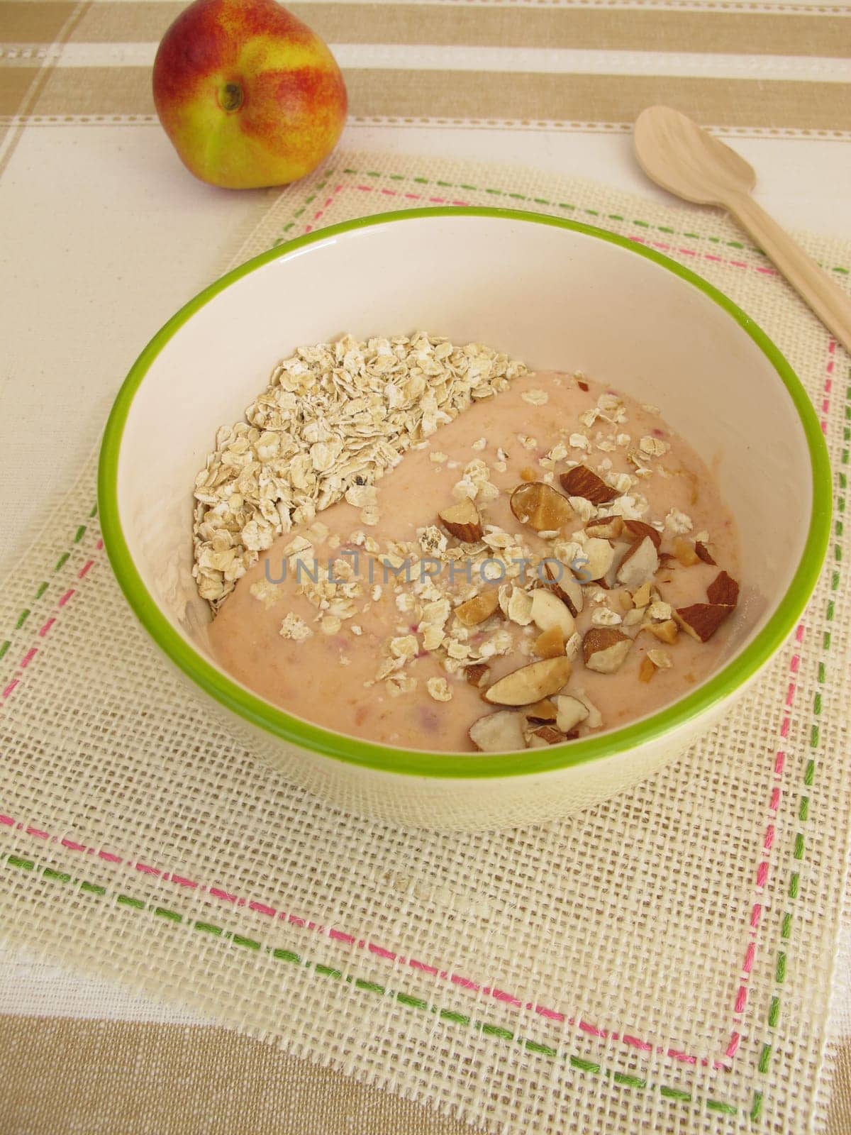 Smoothie bowl for spooning with oatmeal,nectarines and hazelnuts