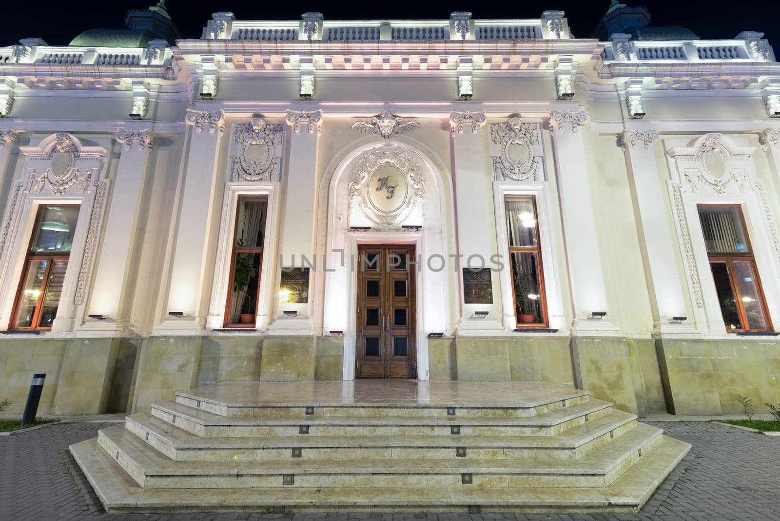 The Azerbaijan State Puppet Theatre in Baku is illuminated at night, highlighting its architectural beauty and serving as a cultural hub for performances and artistic expression