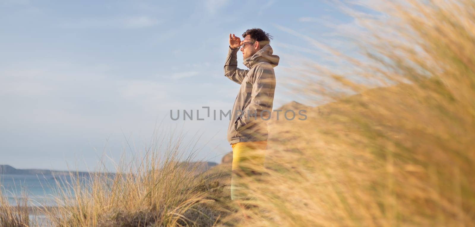 Sporty active man looking at distance, enjoying beautiful nature, freedom and life at serene landscape at Balos beach. Active lifestyle outdoors.