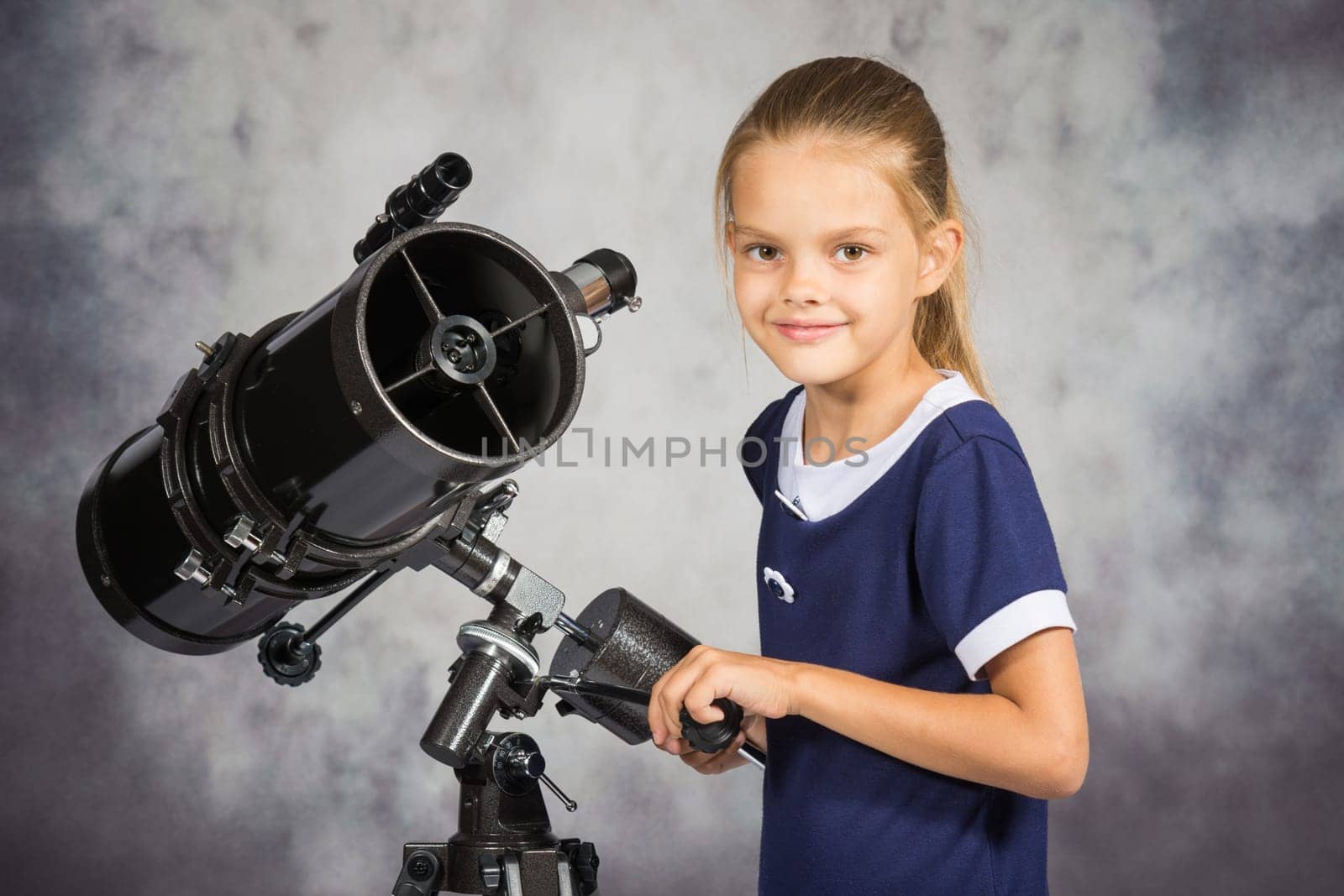 Seven-year girl adjusts the telescope and looked into the frame