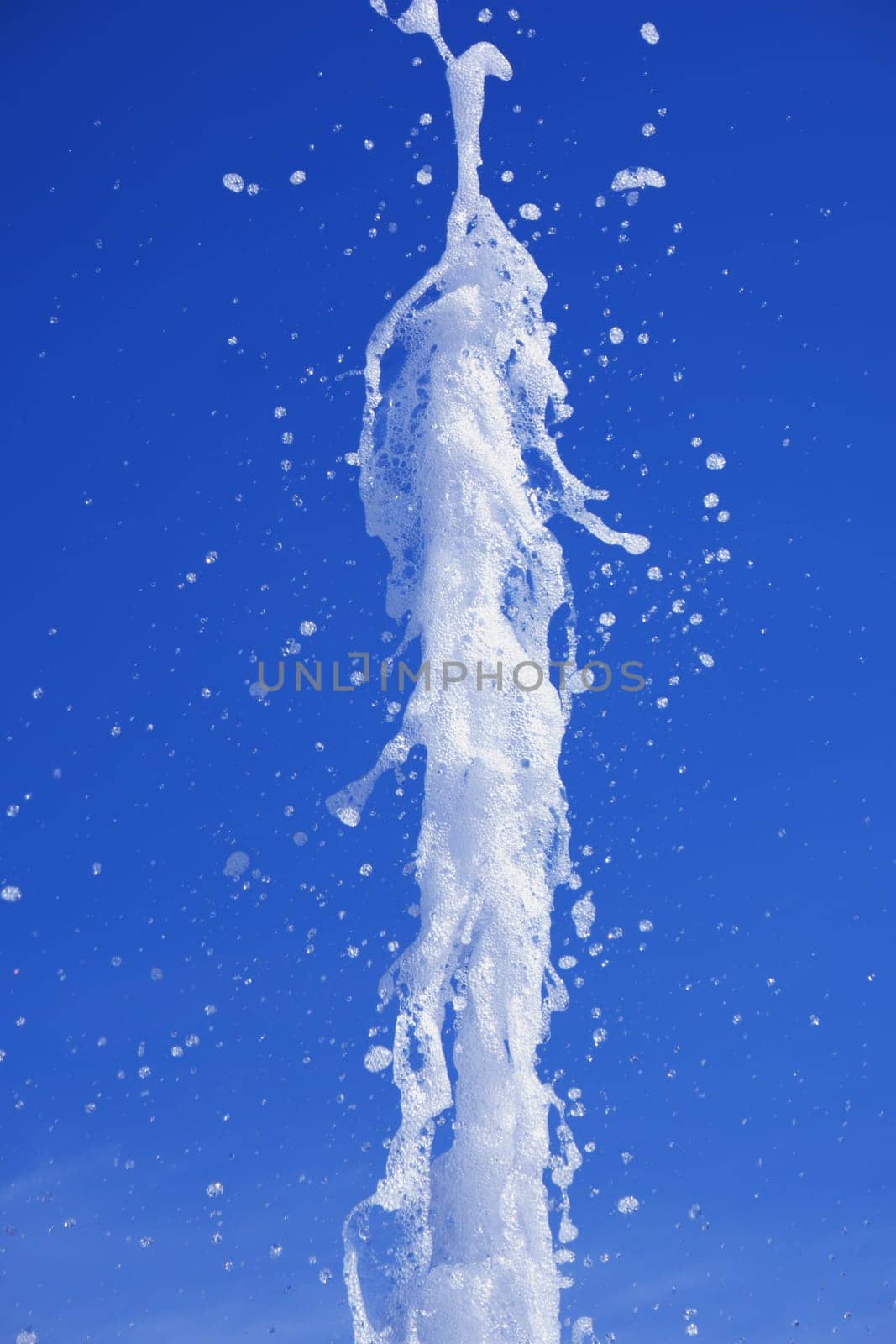 Water stream splashing on blue sky background