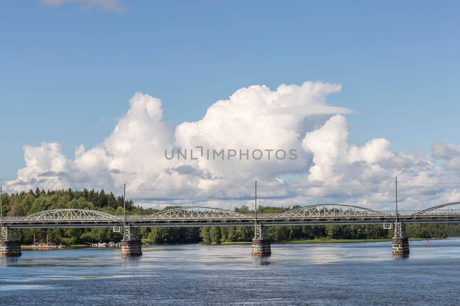 Bridge over River in Umea, Sweden with a partly cloudy sky.