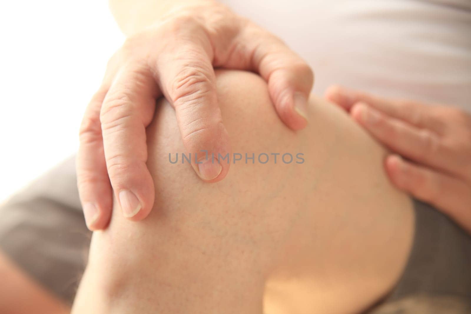 Senior man with a hand on his aching knee