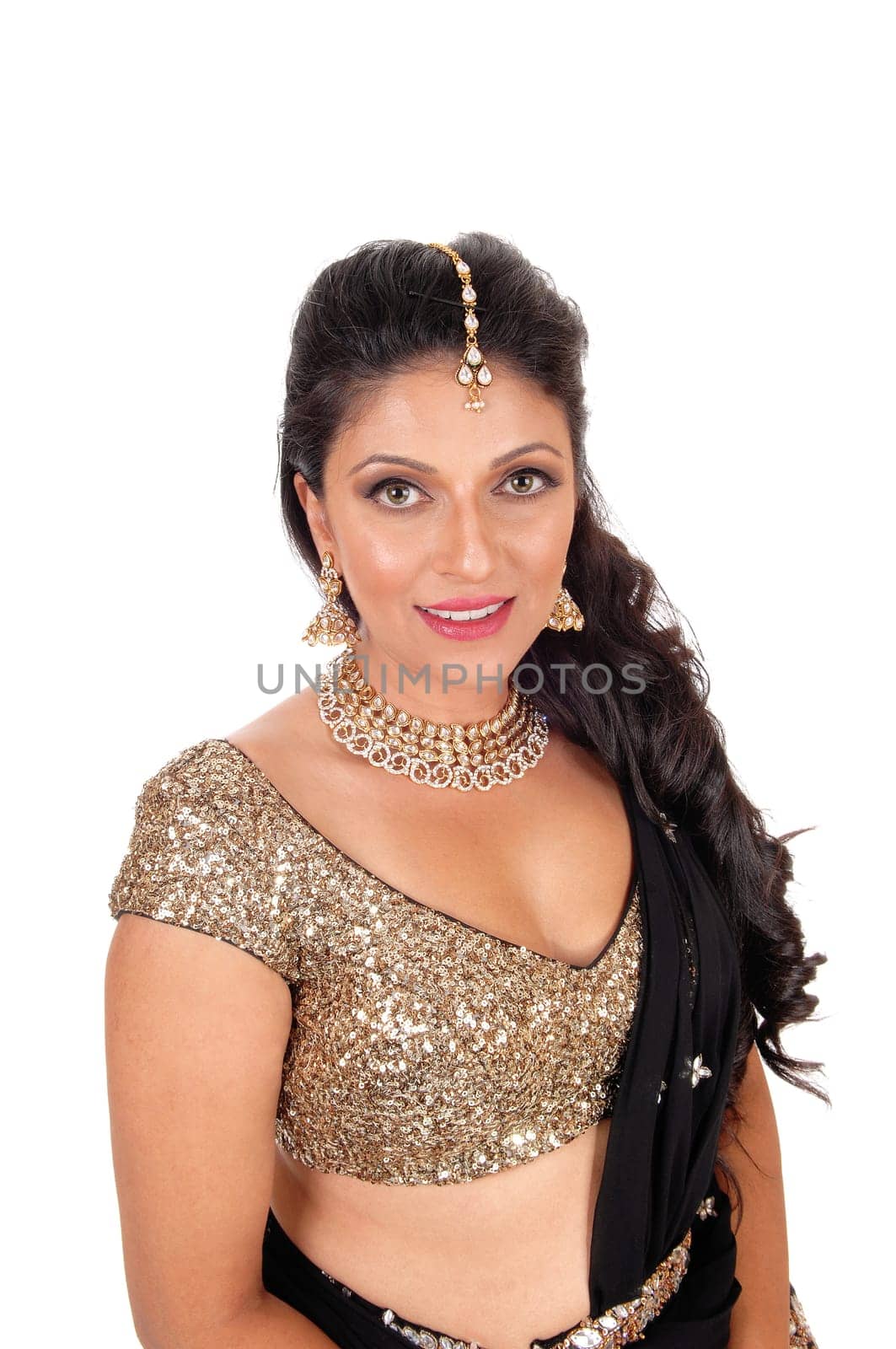 A lovely young woman in a short gold color top and long curly black hair.standing halve length isolated for white background..