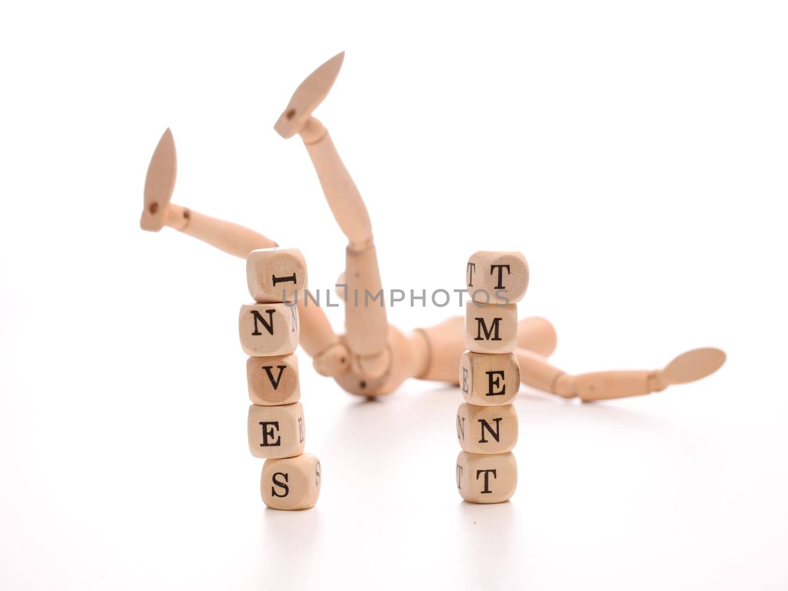 Financial risk concept with a fallen wooden puppet and dices with the word investment