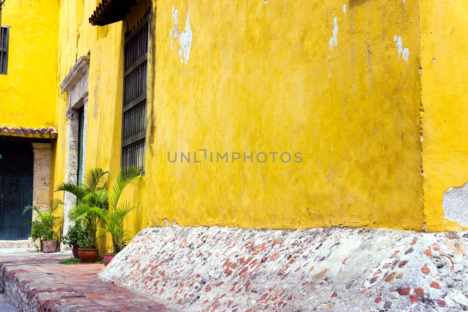 Yellow colonial architecture with lush green plants in Cartagena, Colombia