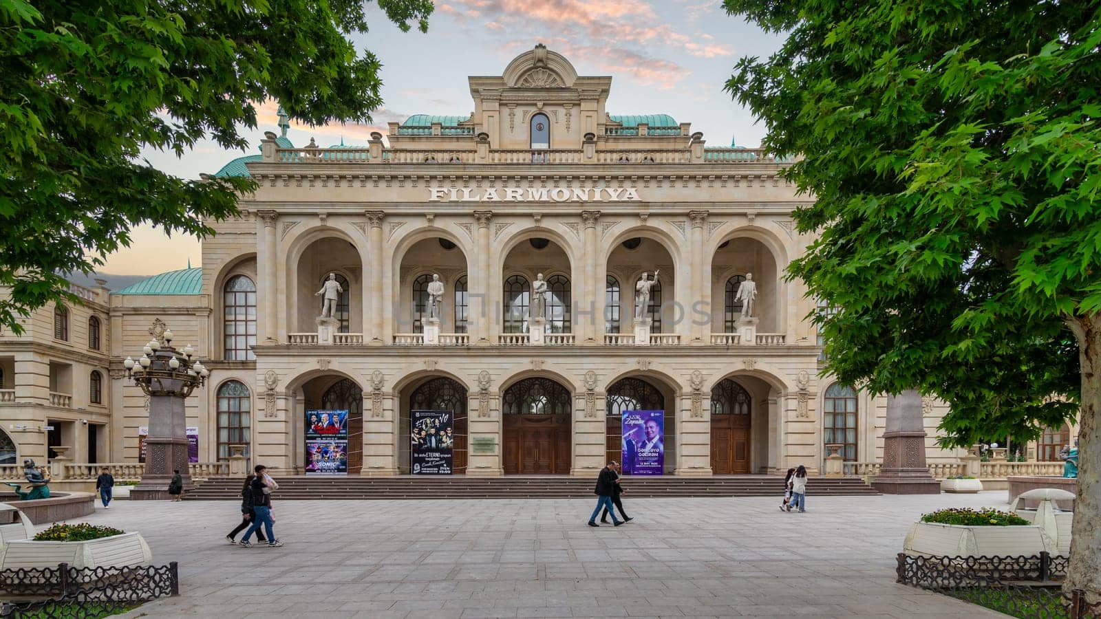 Ganja, Azerbaijan - May 13 2024: Ganja State Philharmonic Hall, renowned for its stunning architecture and cultural performances, features a classical facade adorned with arches, columns, and statues