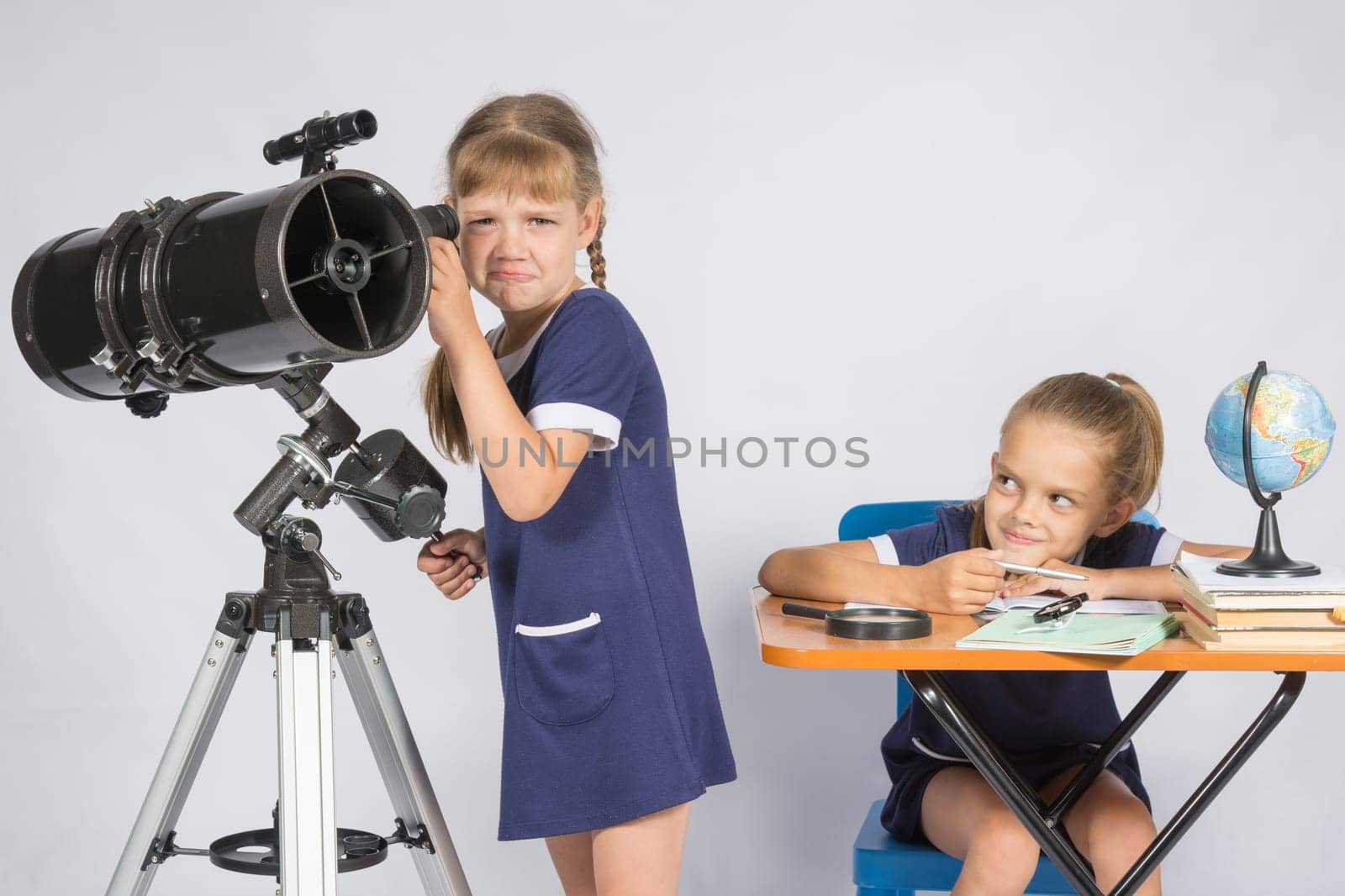 The girl was upset he did not see in the telescope, the other girl mocking her