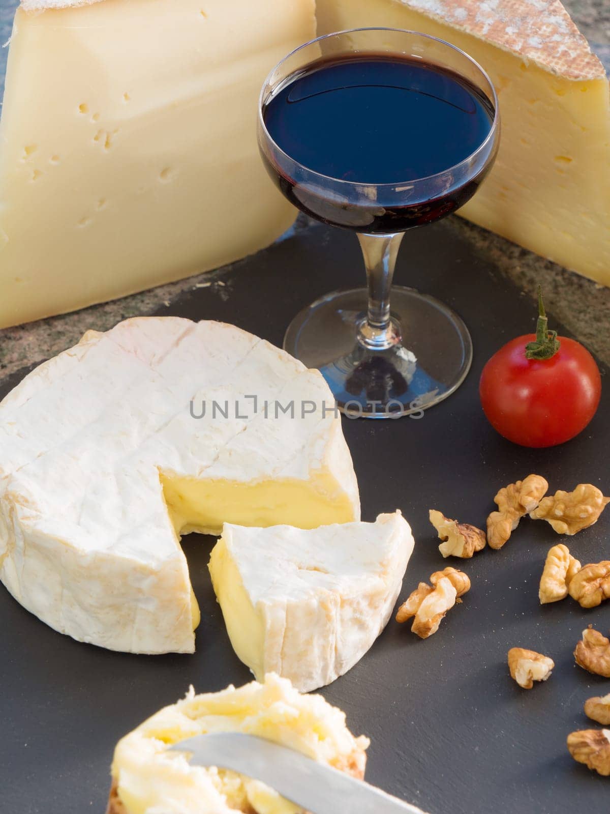 a camembert cheese with a glass of wine