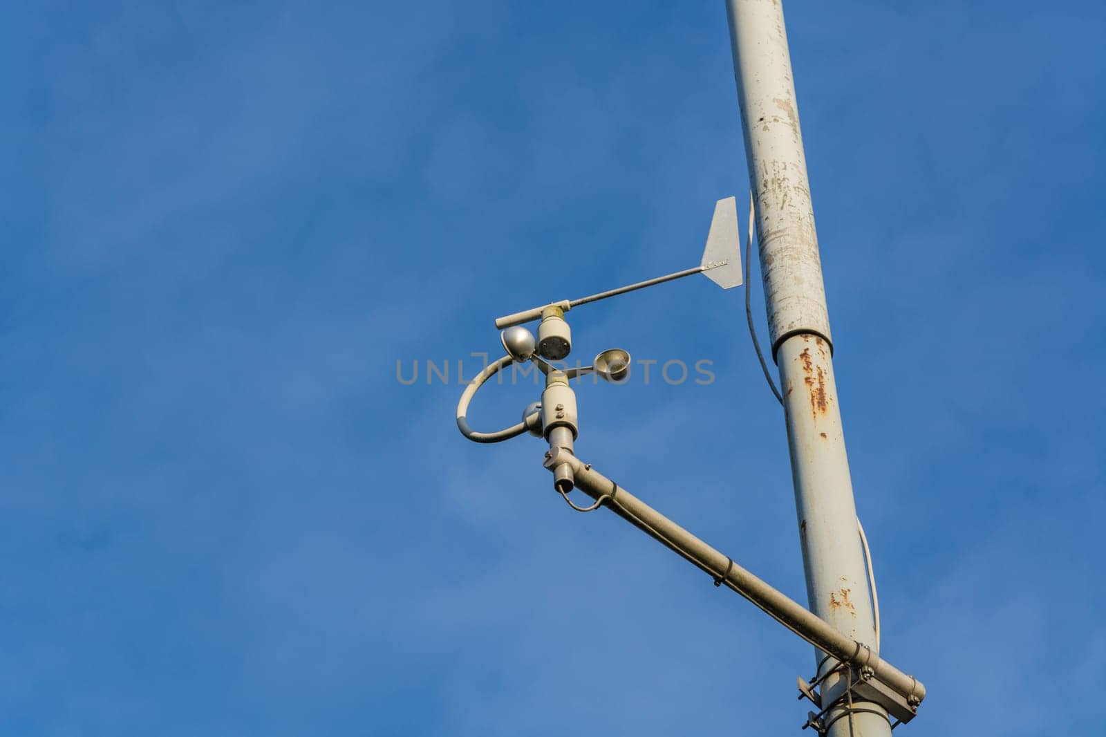 Weather station with anemometer on blue sky..