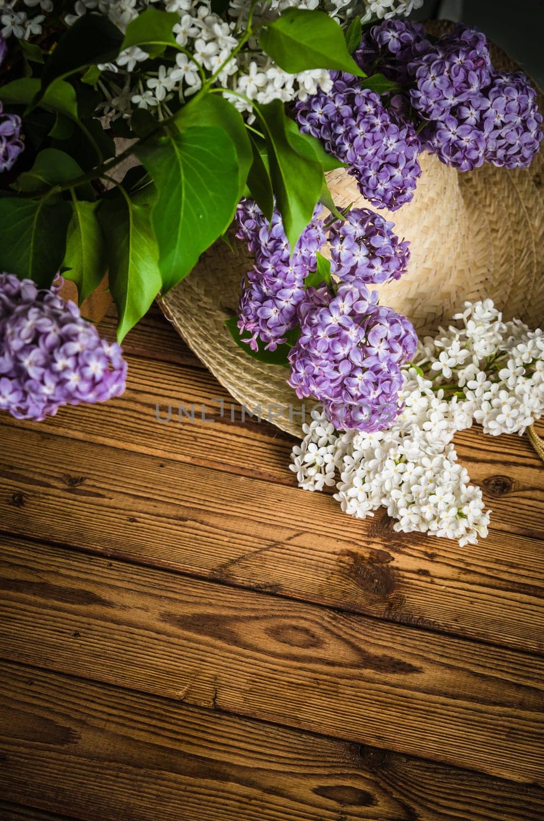 Still-life with a bouquet of lilacs and a straw hat, close-up
